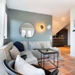 Wohnzimmer mit Sofa, Couchtisch und Küchenbereich im Hintergrund.