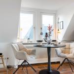 Zimmer mit Esstisch, zwei Stühlen, TV und Fenstern mit Blick.