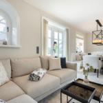 Living and dining area with sofa, table, and windows.