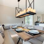 Dining room with wooden table, bench, and modern pendant light.
