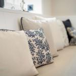Sofa with beige and blue cushions featuring coral pattern