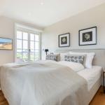 Bedroom with bed, window, and wall pictures
