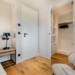 Bedroom with bed, nightstand, closet, and chair.