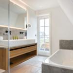 Bathroom with bathtub, sink, and shower. Window with view.
