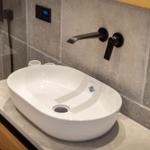 Sink with black faucet and gray wall