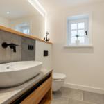 Bathroom with sink, toilet, and window