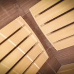 Two rows of wooden benches in a sauna with wooden floor