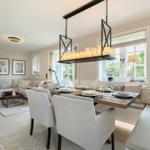 Dining room with table, chairs, and windows. Living area with sofa and fireplace.