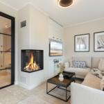 Living room with fireplace, sofa, and TV. Door leads to adjacent room.