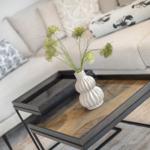 Living area with sofa, cushions, and a coffee table with vase.