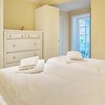 Room with bed, wardrobe, and window to outdoor terrace.