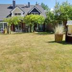 House with large garden and beach chair in foreground.