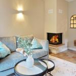 A living room with sofa, fireplace, and round tables.