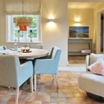 Round table with chairs, armchair and window in dining room.