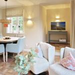 Living and dining area with sofa, table, and TV.