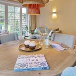 Round table with bottle and glasses, fireplace and seating area in room.