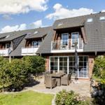 House with balcony, terrace and garden. Outdoor area with table and chairs.