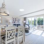 Dining area with table and chairs, living area with sofa and view of the garden.