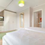 Bedroom with double bed, wardrobe, TV, and mirror.