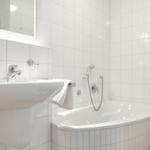 Bathroom with bathtub, sink, and mirror.