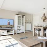 Living and dining area with TV, dining table, and sideboard.