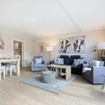 Living and dining area with sofa, armchairs, and dining table.