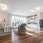 Living room with wooden floor, seating, and television.