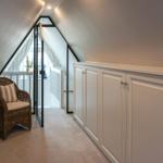 Attic with chair, cabinet, and glass sliding door to terrace.
