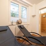 Two lounge chairs by window, sauna in background