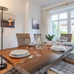 Dining room with wooden table, chairs, and window view