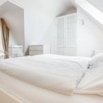 Schlafzimmer mit Dachschrägen, Doppelbett und kleinem Bett.
