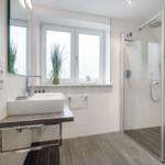 Bathroom with shower, sink, and window