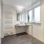 Bathroom with shower, sink, and heater.