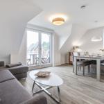Living and dining area with balcony access and wooden floor