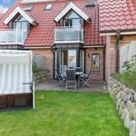 House with terrace, garden, and beach chair. Red tiled roof and stone wall.