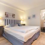 Bedroom with double bed, nightstands, and attached bathroom.