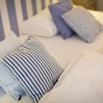 Double bed with pillows and striped headboard.