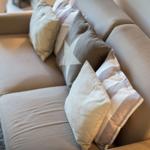 A sofa with multiple cushions on a rug