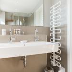 Waschbecken mit Spiegel und Handtuchwärmer an der Wand