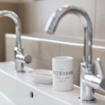 Badezimmer mit zwei Wasserhähnen und einem Waschbecken.