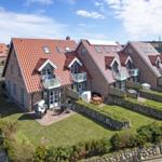 Modernes Mehrfamilienhaus mit Terrassen und Gartenbereich.