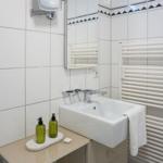 Bathroom with sink, mirror, and towel heater.