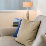 Sofa mit Kissen, Lampe und Bild an der Wand