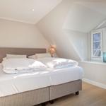 Bedroom with double bed, window, and nightstands.