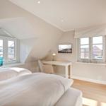 Bedroom with double bed, desk, and windows