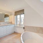 Bathroom with bathtub, sink, and window