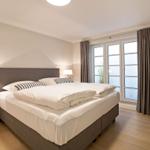 Bedroom with double bed, window, and chair.
