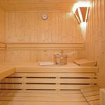 Sauna with wooden bench, bucket, and thermometer.