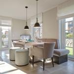 Dining area with table, chairs, and windows to the outside.