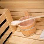 Sauna mit Holztonne, Löffel und Handtuch auf Bänken
